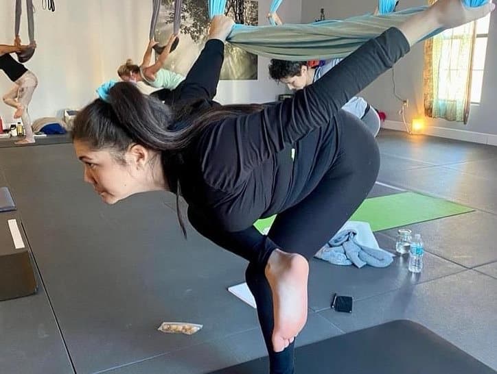 Forward fold with one leg lifted into the hammock